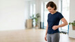 © Xenia - Woman checking her waistline in a bright fitness studio. Concept of weight loss and body awareness