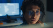 © tirachard - Close-up Black female programmer with code reflection in glasses working late in home office at night. Cybersecurity, AI algorithm, Network security, software developer, serious face, burnout concept.