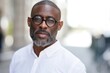 © Studio Nova - The man wearing glasses and white shirt poses confidently outdoors with soft bokeh background