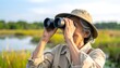© EBG Stock Studio - Persona observando aves con prismáticos en un humedal natural durante una actividad al aire libre