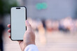 © Hiroba Studio - 帰宅ラッシュ時の夕方の交差点でスマートフォンを手に持って画面を見て操作する顔無しの会社員の男性の手元