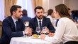 © Liput - Business Professionals Discussing Over Dinner at Formal Restaurant Event