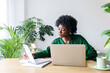 © Westend61 - Businesswoman with laptop reading notes at desk