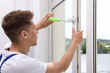 © New Africa - Worker with screwdriver installing window handle indoors