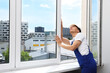© New Africa - Professional worker examining window after installation indoors
