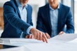 © Tata - Two men in blue blazers pointing at architectural blueprints corporate planning