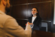 © Serhii - Hotel receptionist welcoming guest at front desk