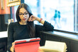 © Antonio Recena - Pretty, brunette woman has a coffee in a bar while she looks at her tablet and consults a book