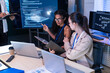© winnievinzence - Focused female software engineer discuss project script via laptop. Diverse tech startup coder woman use tablet to check computer program code and web database development in office meeting