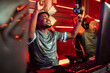 © Marko Geber - Two gamers celebrating esports team victory in gaming arena