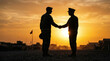© drims - Silhouette of soldiers shaking hands during sunset on a base