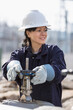 © Connect Images - Female power engineer adjusting water valves at power plant