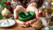 © Salwa - Cupped hands hold coiled, green snake against a bokeh-lit holiday scene with gold ornaments and greenery