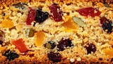 Close-up texture shot of a dense fruitcake's crumb, showcasing dried fruits and nuts.