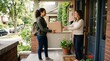 © Felippe Lopes - Delivery person hands a package to a happy woman at her front door on a sunny day
