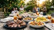© Sukon - Delicious grilled meats and fresh corn on the cob served with colorful salads at a summer backyard barbecue.