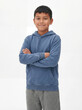 © GraphicLoom - A cheerful young boy of mixed ethnicity stands confidently with his arms crossed against a clean, bright white studio background.