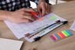 © New Africa - Man using planner at wooden table indoors, closeup