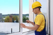 © New Africa - Professional worker with screwdriver installing window indoors