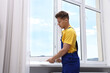© New Africa - Professional worker examining window after installation indoors