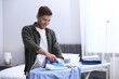 © New Africa - Man ironing shirt on board at home
