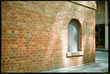 © Rowena Naylor/Stocksy - Beautiful light hits brick wall on city street.  Shot on film.