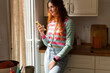© Alba Vitta Studio/Stocksy - Woman use  Phone  in Kitchen