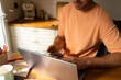 © Alba Vitta Studio/Stocksy - Man Working on Laptop Phone in  Kitchen