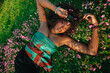 © Ani Dimi/Stocksy - Young  Black  woman laying on grass smiling