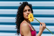 © Tania Cervian/Stocksy - Woman holding yellow gerbera daisy