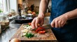 © gabriel - Man in blue apron chopping vegetables on wooden cutting board in kitchen