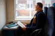 © Artcore Studio/Stocksy - Commuter reading book by train window