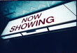 © Rowena Naylor/Stocksy - Movie Theater Sign Shows Now Showing Information at Night