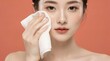 © Ilham - Woman cleanses her face with a soft white cloth to remove daily makeup impurities.