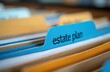 © Vadym - Close up of blue file folder tab labeled estate plan in office filing cabinet. Documents organize personal wealth, future legacy. Secure financial records for safe keeping. Legal papers sorted for