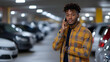 © Hanna - Young African American man talking on his smartphone in an indoor parking garage