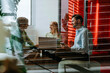 © Westend61 - Business colleagues having meeting with laptop in modern glass office