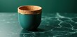 © Viktor - Teal cup with cork rim and gold accent sits on dark green marble surface. Smooth background is a deep teal shade. Minimalist elegant drinkware.