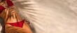 © Nikolay - Fit woman in red bikini lying on sandy beach under palm leaf shadow with copy space