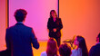© Lustre Art Group  - Businesswoman listening to audience question during seminar with blank screen. Concept of business workshop, team interaction, professional coaching, public speaking and conference learning.