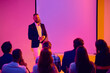© Lustre Art Group  - Smiling male presenter standing before blank screen during business seminar. Concept of corporate workshop, friendly leadership, training event, business education and speaker confidence.