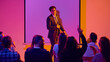 © Lustre Art Group  - Smiling young businessman leading audience question session in colorful seminar space. Concept of Q and A meeting, business coaching, team learning, confident speaker training and corporate education.