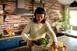 © Davor - Smiling woman unpacking fresh groceries in home kitchen