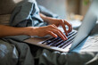 © Davor - Person working on laptop in bed at home