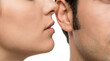 © traxx - Close-up of a young woman whispering a secret directly into a man's ear