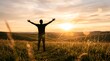 © nasrin - Silhouette of a person with open arms enjoying a breathtaking sunset over rolling hills and fields