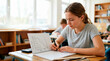 © Xenia - Focused teenage girl student drawing a line graph in a notebook. High school student studying math in classroom