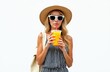 © Maryna - Young woman drinks orange juice from plastic cup. She wears straw hat sunglasses and striped dress. Girl has backpack, enjoys summer refreshment outside. Refreshing beverage hydration.