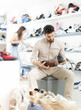 © JackF - Adult male customer sits on bench, trying leather oxfords or derbies while checking fit and style
