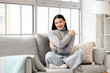 © Pixel-Shot - Beautiful young woman hugging herself on sofa at home